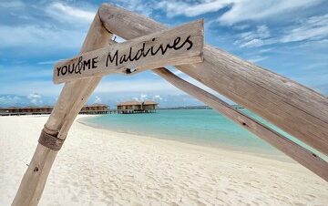 You and Me by Cocoon Maldives sign on the beach with clear blue sky