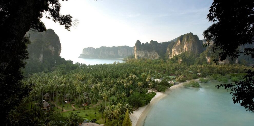 Aerial view of Rayavadee Krabi surrounded by palm trees lush landscape and dramatic cliffs