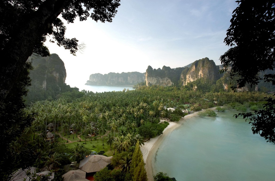 Aerial view of Rayavadee Krabi surrounded by palm trees lush landscape and dramatic cliffs