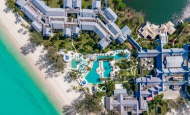 Aerial view of Saii Laguna resort beachside with pools and lush greenery