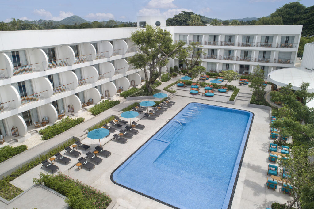 Aerial view of the swimming pool at Avani Chaweng Samui surrounded by sun loungers and guest rooms