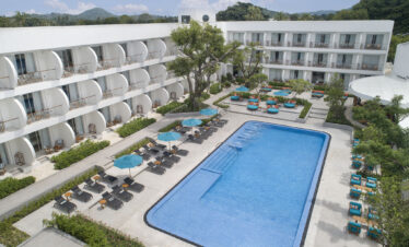 Aerial view of the swimming pool at Avani Chaweng Samui surrounded by sun loungers and guest rooms