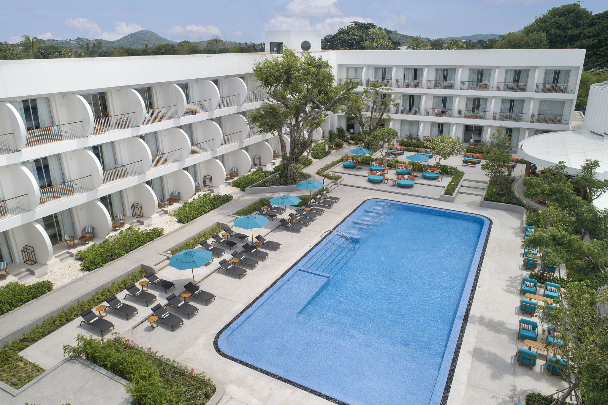 Aerial view of the swimming pool at Avani Chaweng Samui surrounded by sun loungers and guest rooms