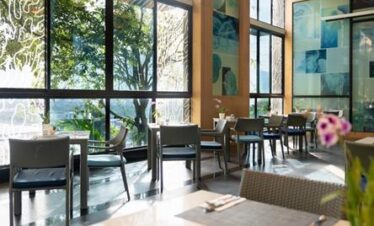 Bright dining area at Amari Phuket with large windows and greenery outside