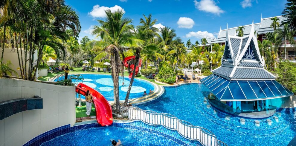 Chada Thai Village pool area with water slides and lush tropical surroundings on a sunny day