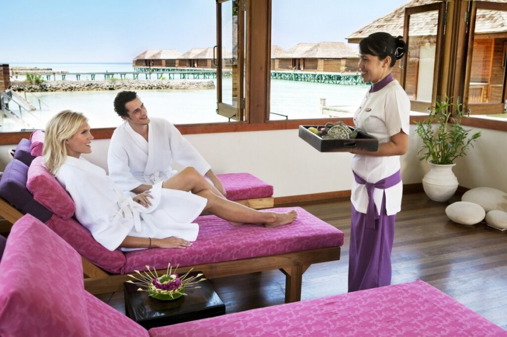 Couple relaxing at Veligandu spa with oceanfront view