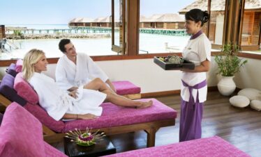 Couple relaxing at Veligandu spa with oceanfront view
