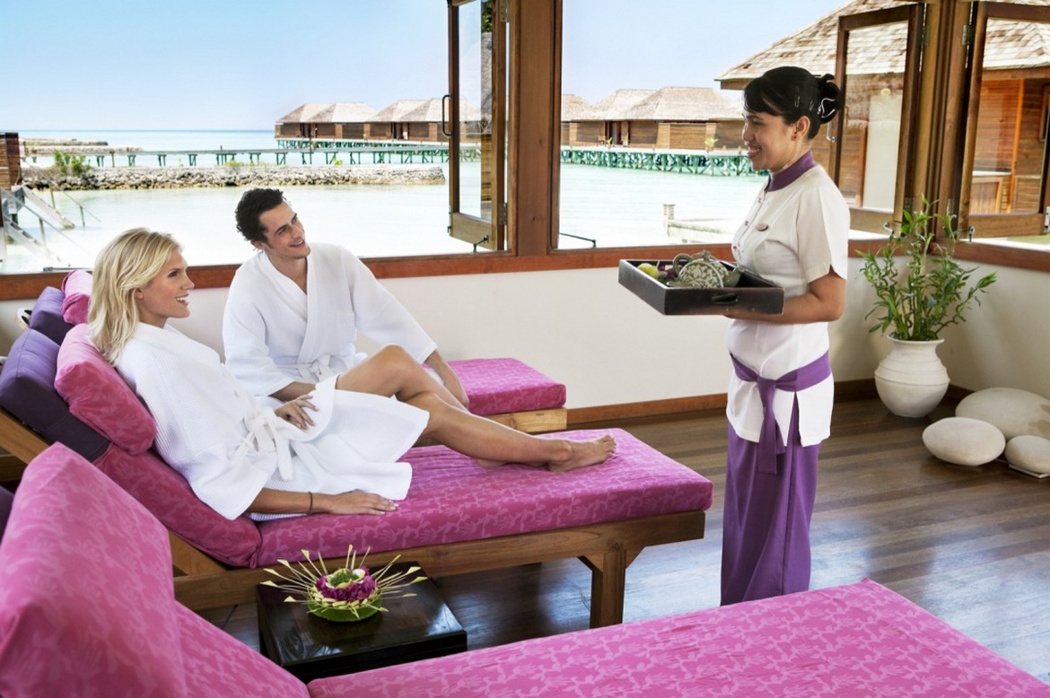 Couple relaxing at Veligandu spa with oceanfront view