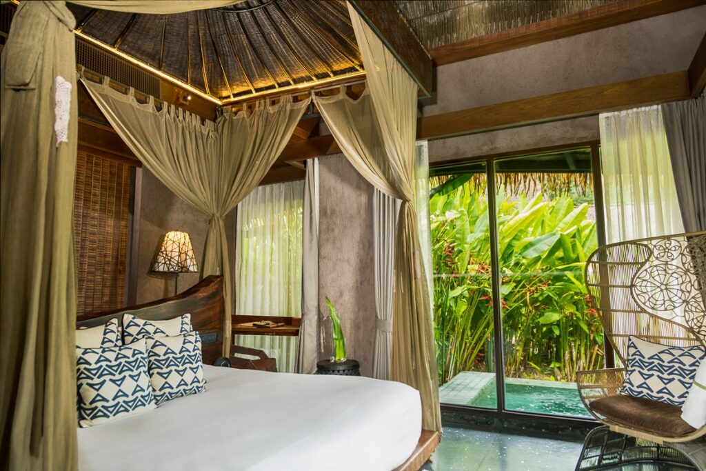 Elegant bedroom with canopy bed and view of lush greenery at Keemala