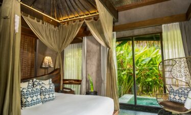Elegant bedroom with canopy bed and view of lush greenery at Keemala