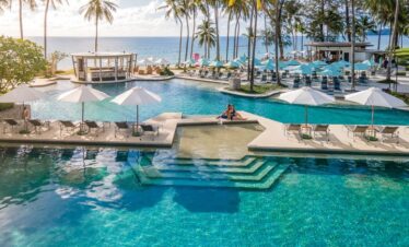 Infinity poolside with views of Saii Laguna and palm trees near the ocean