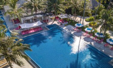 Kandima infinity pool with pink loungers and shaded cabanas