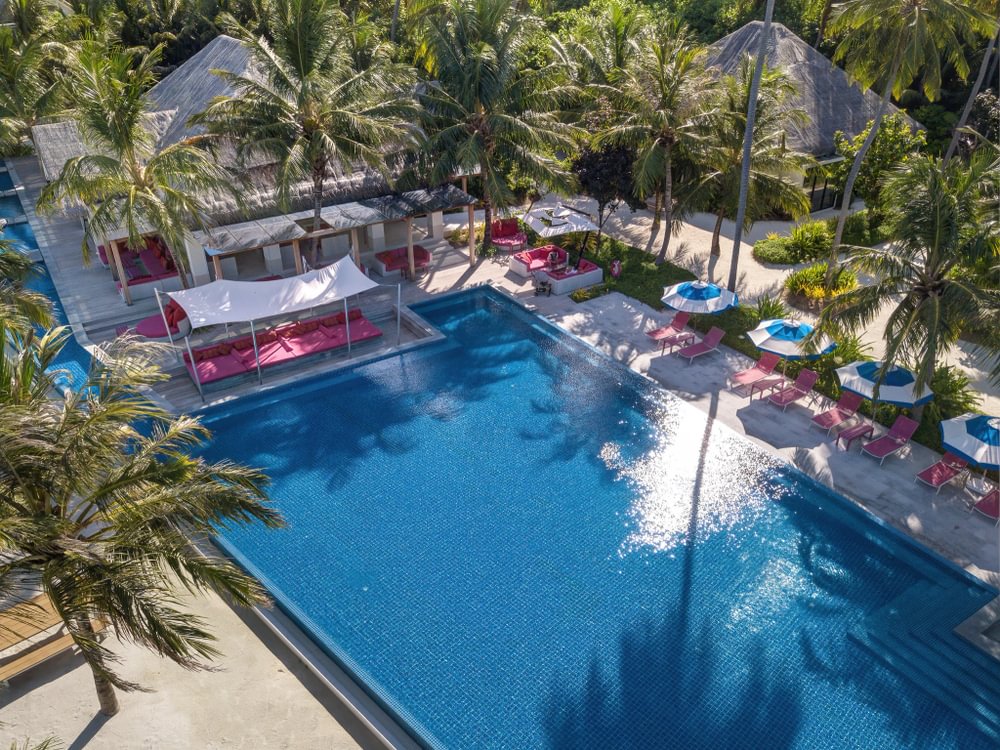 Kandima infinity pool with pink loungers and shaded cabanas