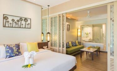 Katathani deluxe room with spacious bed and seating area overlooking the garden