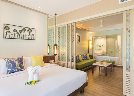 Katathani deluxe room with spacious bed and seating area overlooking the garden