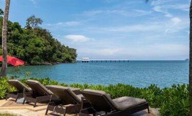 Lounge chairs by the sea with a view of Amari Phukets serene coastline