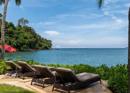 Lounge chairs by the sea with a view of Amari Phukets serene coastline