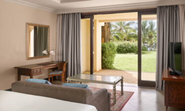 Luxurious garden view room at The Westin Turtle Bay Resort and Spa with glass doors leading to a patio