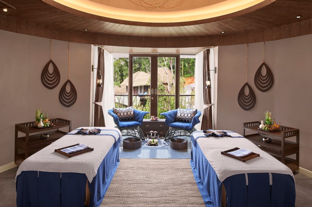 Luxurious spa room with massage tables and forest views at Keemala