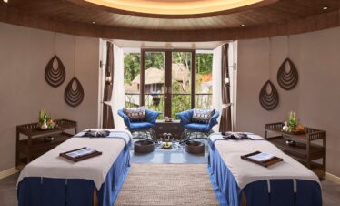 Luxurious spa room with massage tables and forest views at Keemala