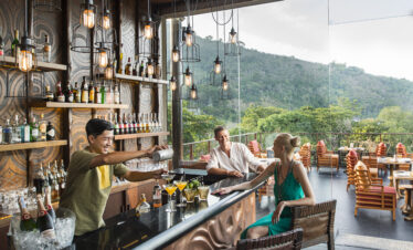 Outdoor bar area with patrons enjoying drinks and scenic views at Keemala