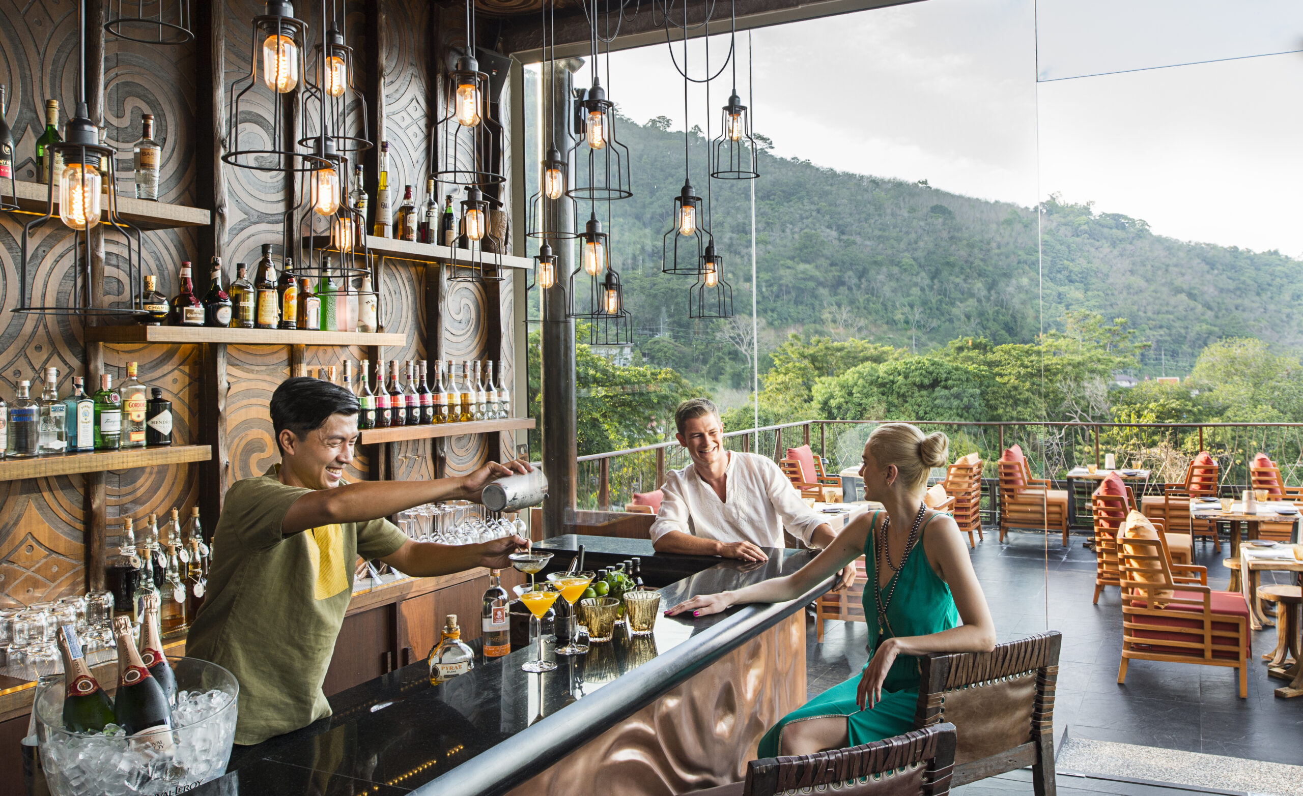 Outdoor bar area with patrons enjoying drinks and scenic views at Keemala