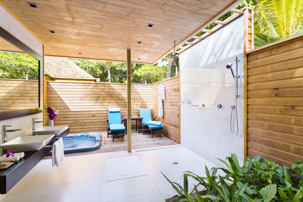 Outdoor bathroom with jacuzzi and loungers at Veligandu