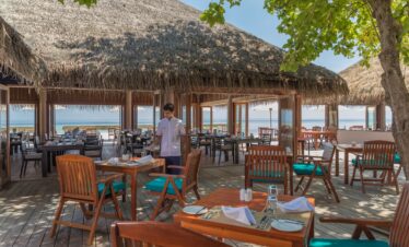 Outdoor dining area with ocean views at Veligandu Maldives