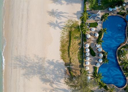 Overhead view of Katathani pool and sandy beachfront lined with loungers
