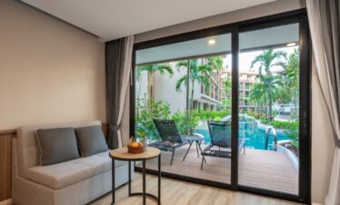 Poolside view from a cozy room with sofa seating at La Flora Khao Lak with a serene outdoor ambiance
