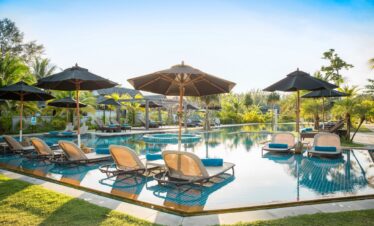 Poolside view with lounge chairs at Robinson Khao Lak