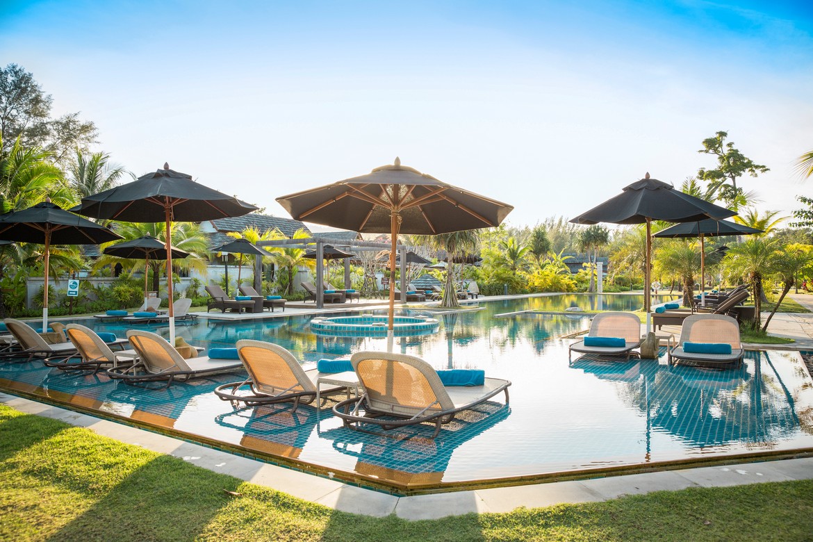 Poolside view with lounge chairs at Robinson Khao Lak