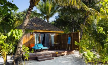 Private villa with lush greenery on Veligandu sandy beachfront