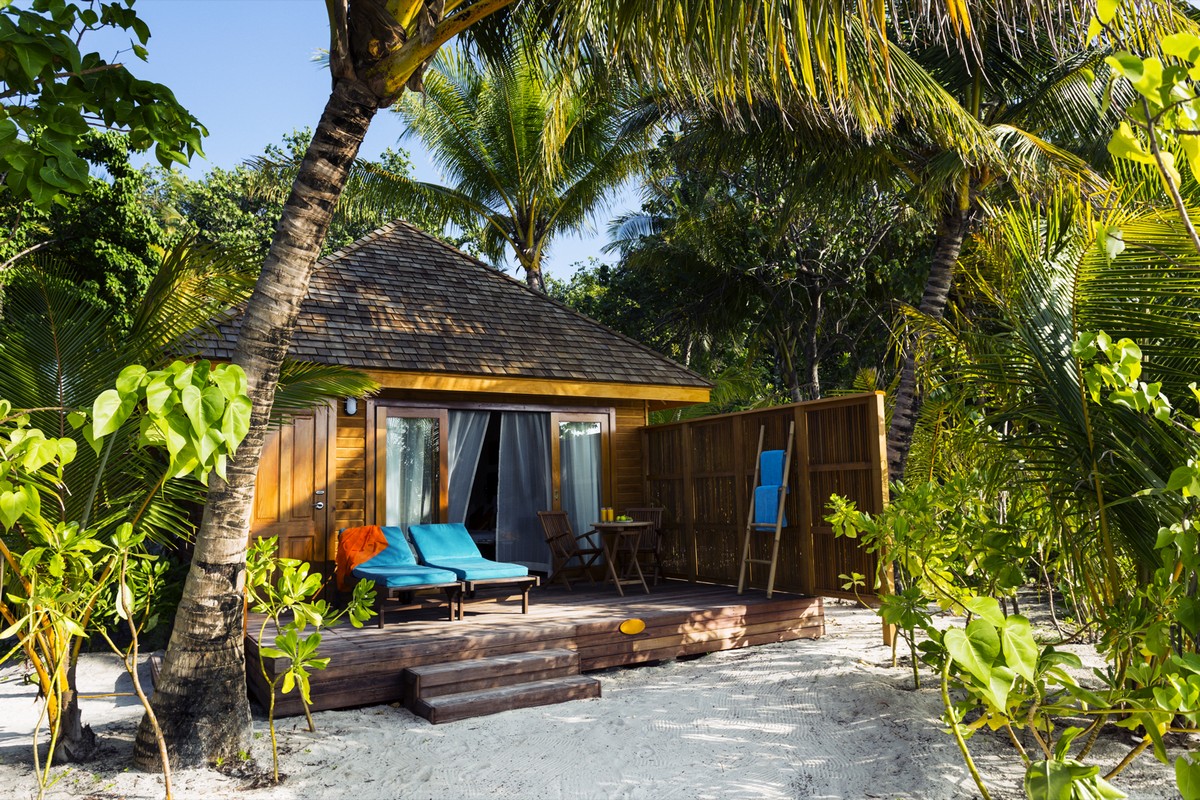 Private villa with lush greenery on Veligandu sandy beachfront