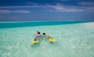 Snorkeling in turquoise waters near Veligandu island beaches