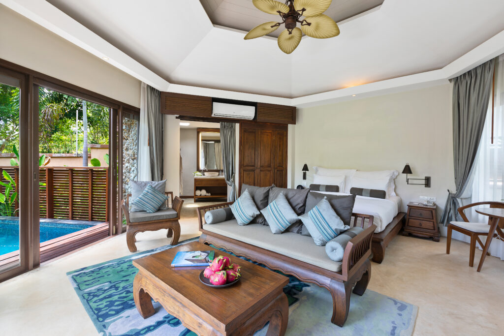 Spacious room at Saii Koh Samui with wooden furniture and a view of the private pool