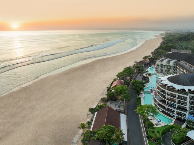 Aerial view of Double Six Seminyak with a long sandy beach at sunrise