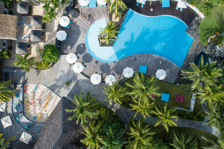 Aerial view of Solana Beach pool area with sunbeds umbrellas and tropical greenery