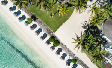Aerial view of Solana Beach sunbeds and umbrellas lined along the pristine sandy shoreline