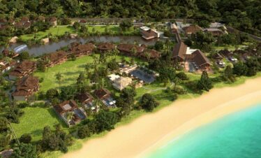 Aerial view of a tropical resort by the beach featuring lush greenery Story of serene natural beauty