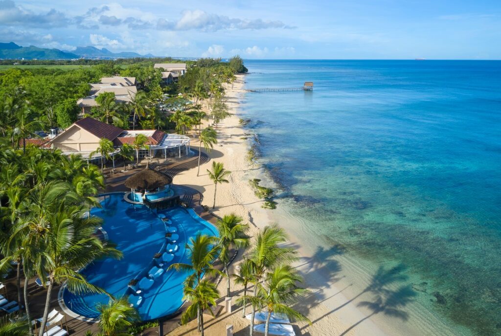 Aerial view of beach and resort pool at Nirvana At Le Meridien Ilse Mauritius showcasing crystal clear waters