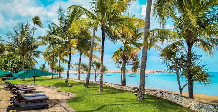 Beachfront lounge area at Patra Bali Resort and Villas with sunbeds