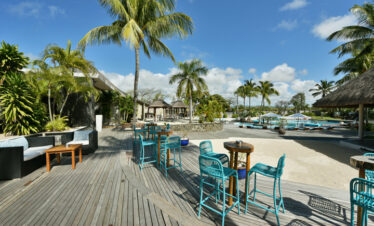 Beachside deck at Solana Beach with high stools and tables under palm trees