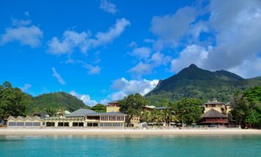 Coral Strand Hotel Seychelles with mountain backdrop and sandy beach