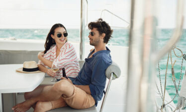 Couple enjoying a drink on a yacht in the ocean near Paradise Cove Boutique