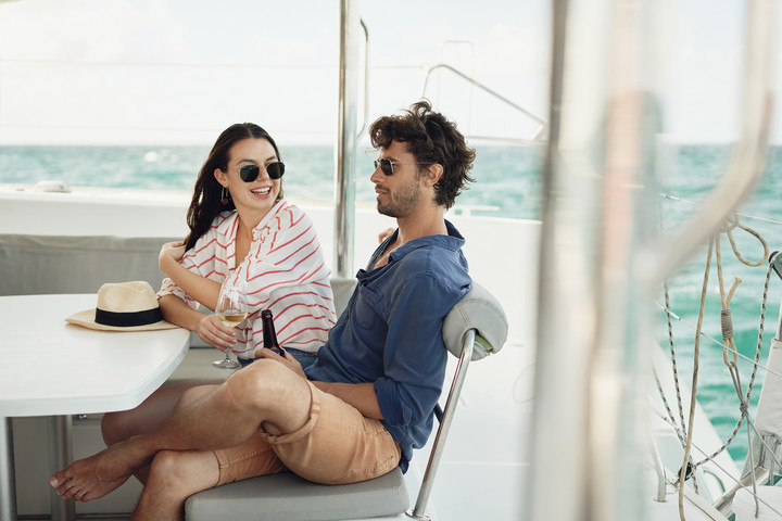 Couple enjoying a drink on a yacht in the ocean near Paradise Cove Boutique