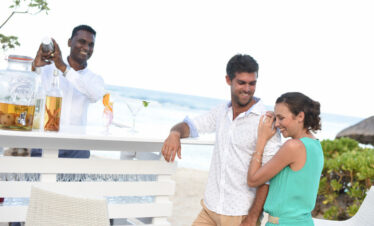 Couple enjoying drinks beachfront bar Radisson Blu Poste Lafayette
