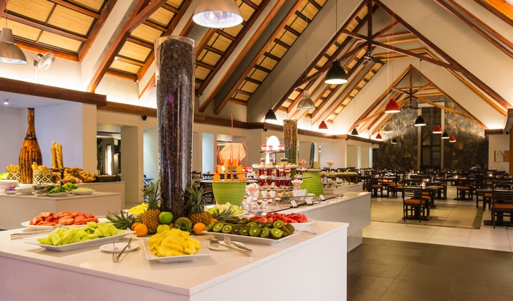 Crystals Beach Resort dining with fresh fruit displays under a vaulted ceiling