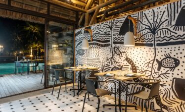 Dining area with artistic decor at Lagoon Attitude Mauritius overlooking the pool at night
