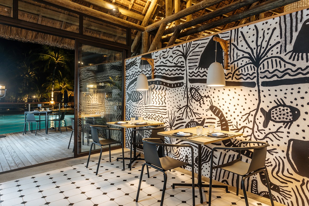 Dining area with artistic decor at Lagoon Attitude Mauritius overlooking the pool at night